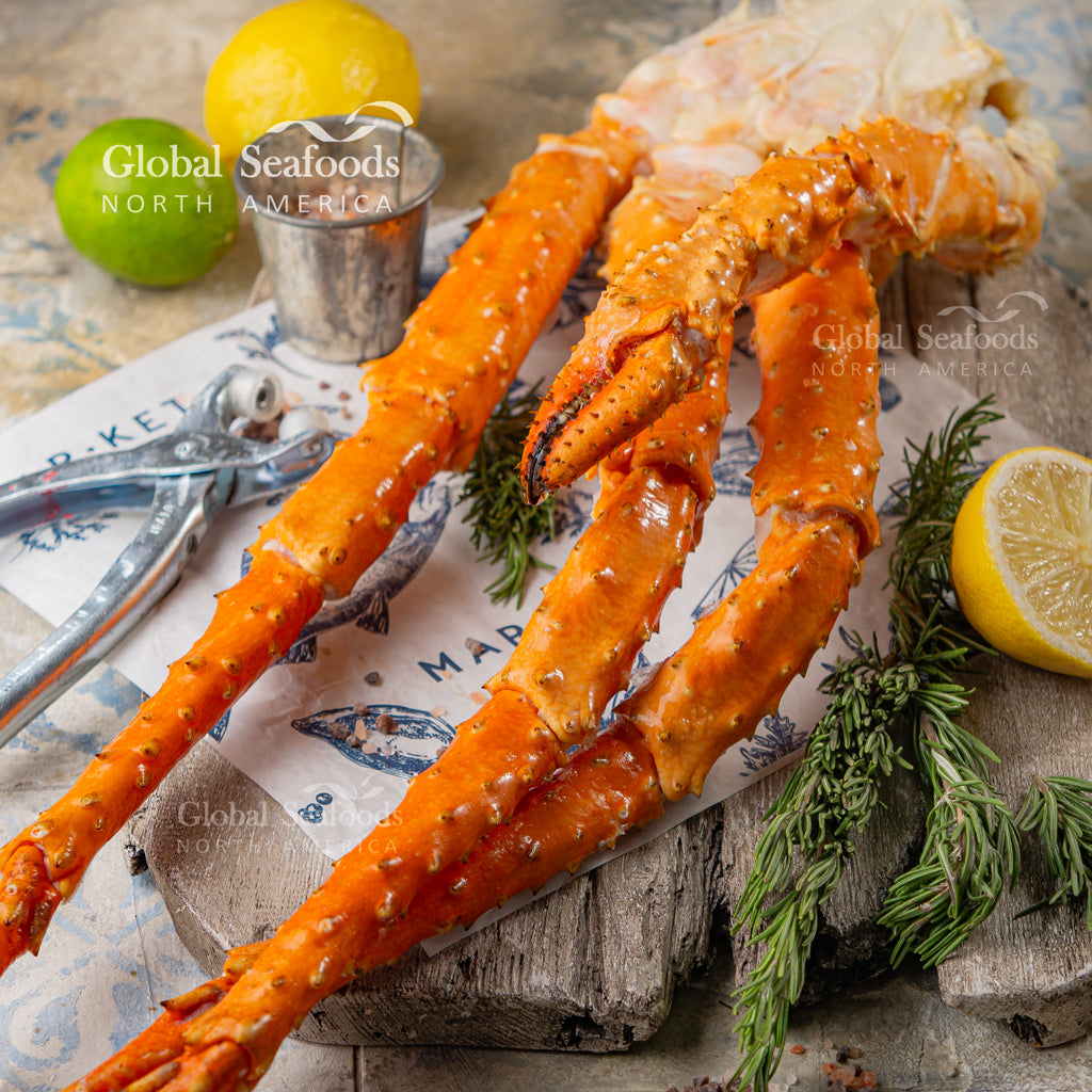 Cooked golden king crab legs on parchment with sliced lemon