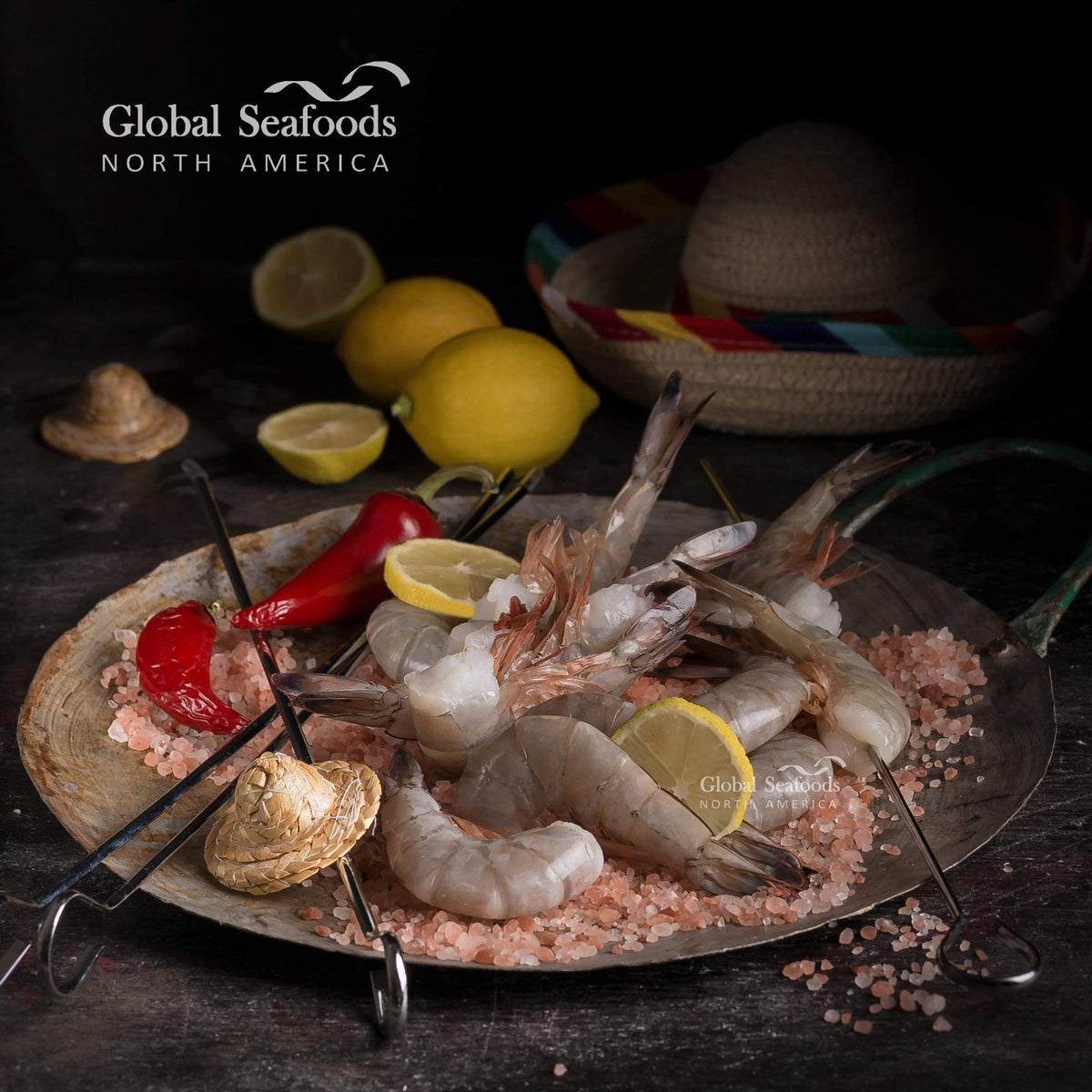 Shrimp skewers on a dark serving plate with lemon