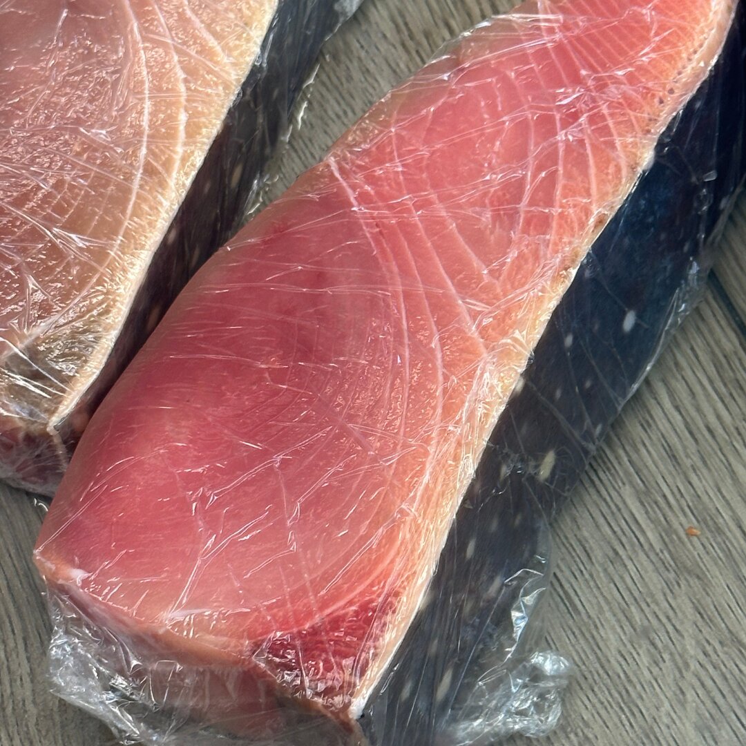 Close-up of pink opah fillets wrapped in clear plastic
