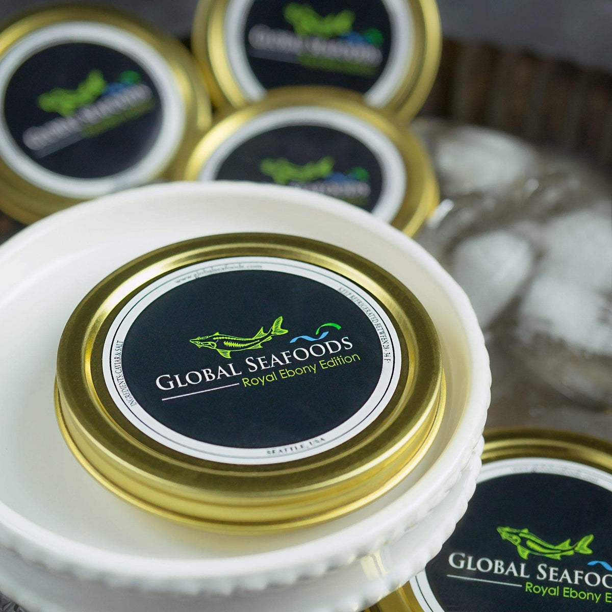 Closed Global Seafoods caviar tin on a white plate with more tins in the background
