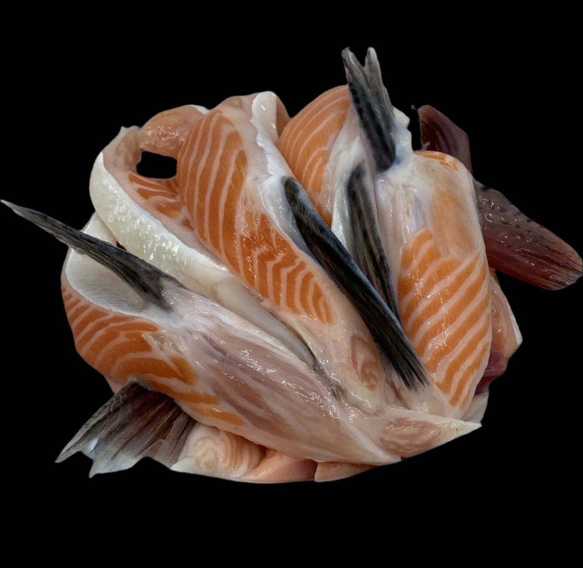 Skin-on king salmon belly strips arranged against a black background