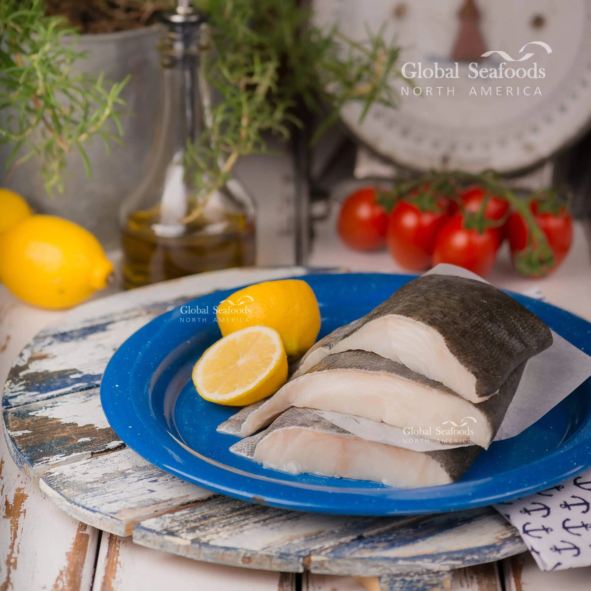 Sablefish fillet portions on a blue plate with a halved lemon.