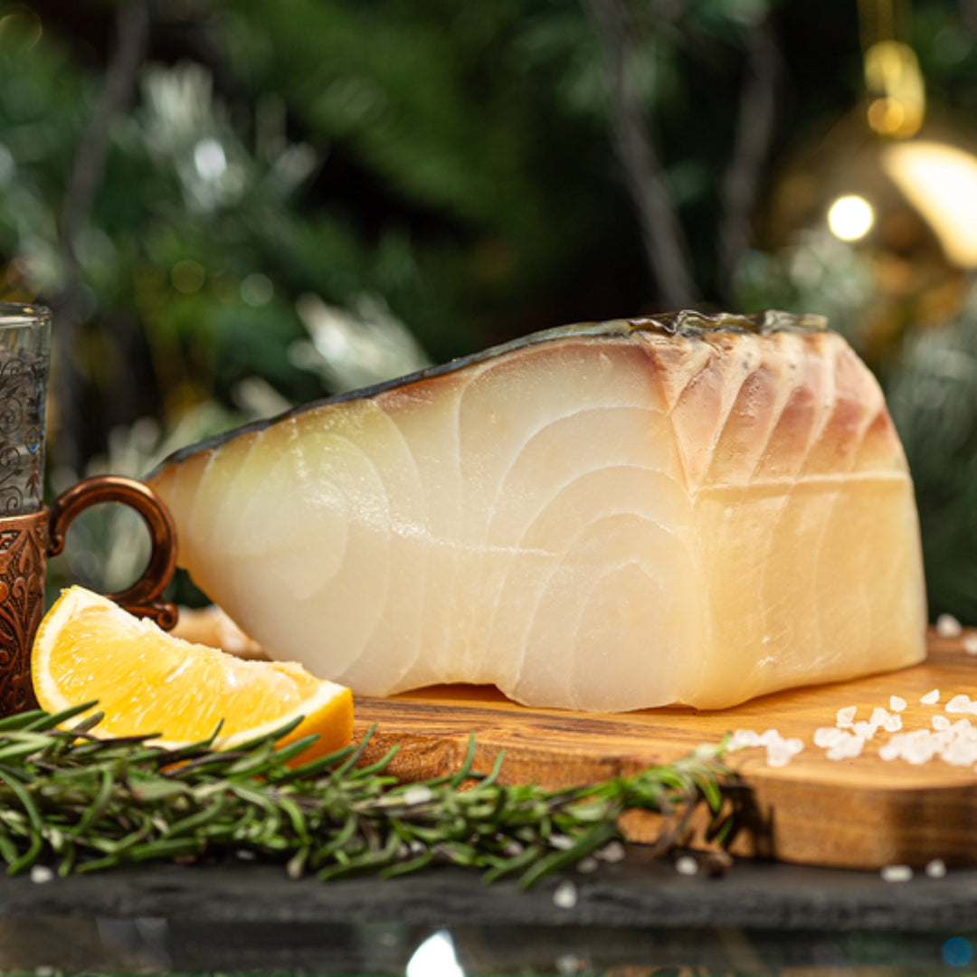 Smoked sturgeon displayed whole or in portions on a rustic wood board, ready for slicing and gourmet serving