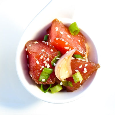 Albacore tuna poke served in a clear cup, showcasing tender pink cubes of tuna for a fresh, ready-to-eat seafood dish