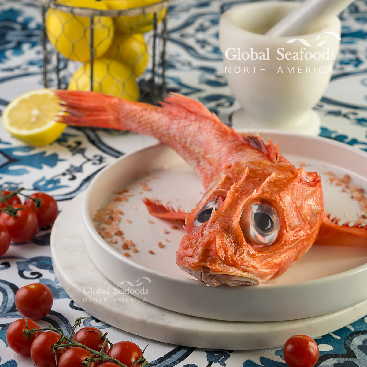 Whole kinki rockfish on a white plate, viewed from the head
