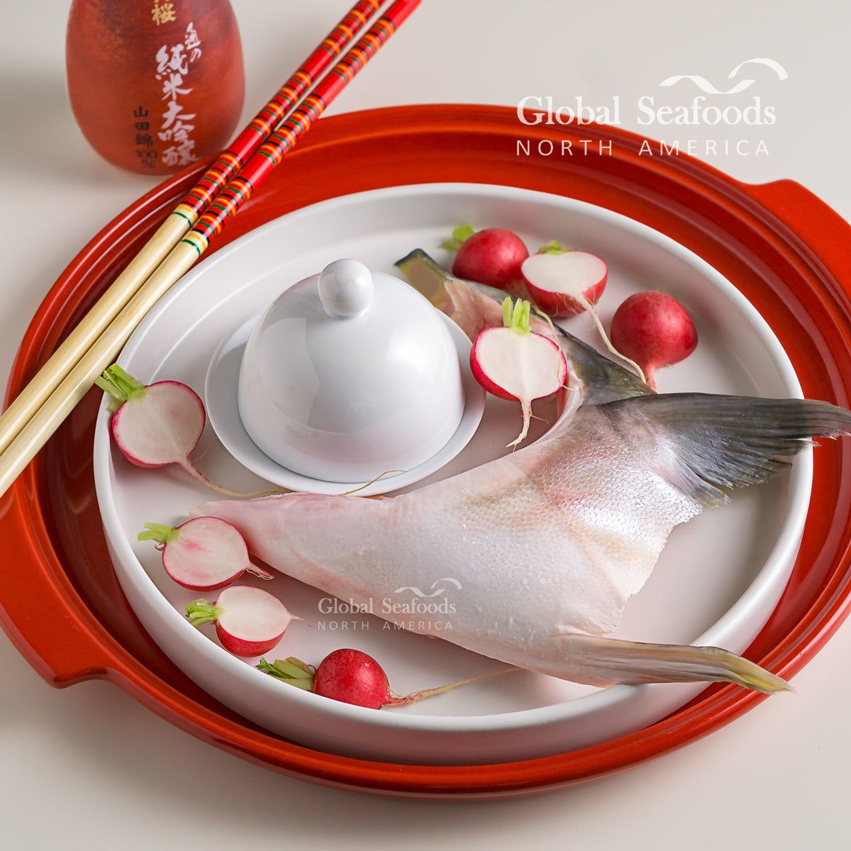 Hamachi (yellowtail) collar on a patterned plate with radishes and chopsticks