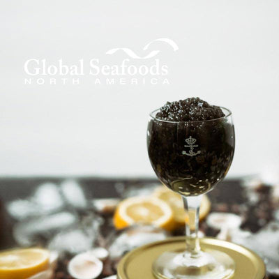Sevruga Sturgeon Caviar elegantly served in a glass cup placed on top of a golden tin, highlighting the delicate texture and luxury presentation of this premium black caviar