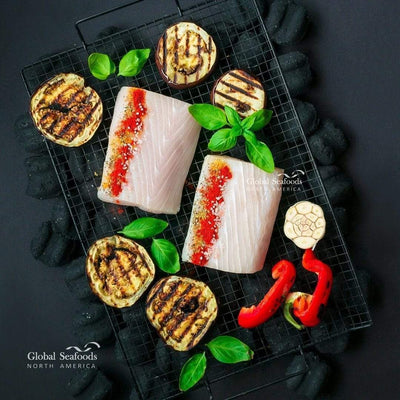 Mahi Mahi fillets on a grill rack, topped with spices and served alongside grilled vegetables for a flavorful and colorful seafood dish