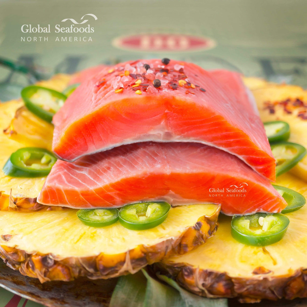 Two skin-on king salmon portions on pineapple slices