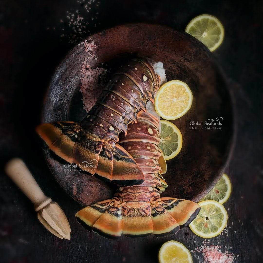 Lobster tails on a metal plate with lemon