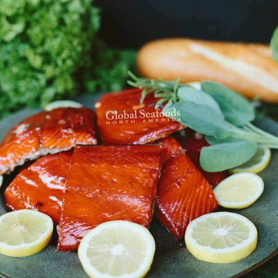 Hot-smoked sockeye salmon portions arranged on a green plate, showcasing their rich red color and flaky texture for a bold and appetizing seafood presentation