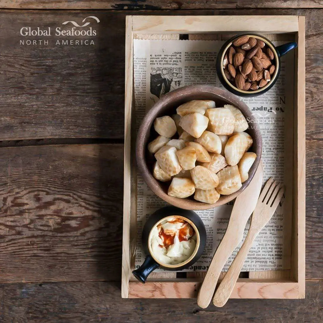 Smoked Weathervane scallops in a cup on a wooden tray