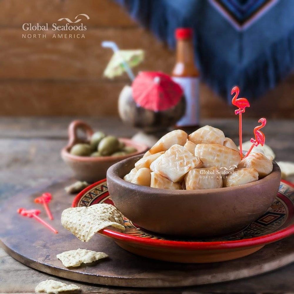 Smoked sea scallops served in a brown bowl, placed on a colorful Mexican-style patterned plate, all set on a brown stone surface for a vibrant and rustic seafood presentation