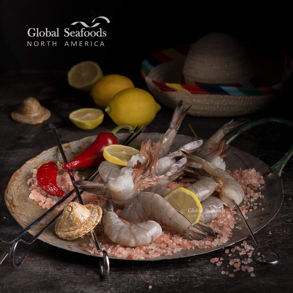 Shrimp skewers on a dark serving plate with lemon