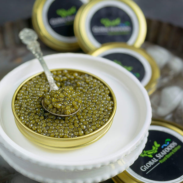 Open tin of Imperial Gold Ossetra caviar with a spoon of olive-gold roe on a white plate