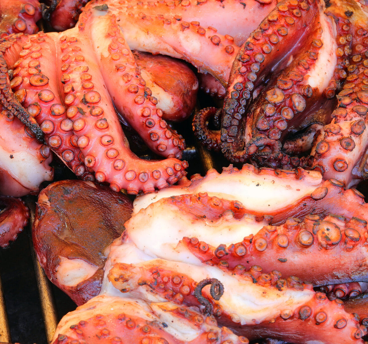 Octopus tentacles grilling over a flame